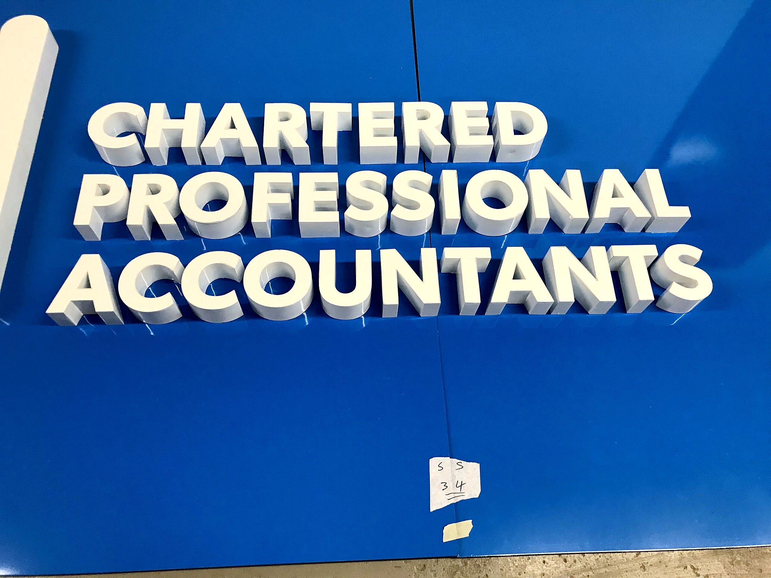 Close-up of white dimensional letters reading Chartered Professional Accountants on a blue panel