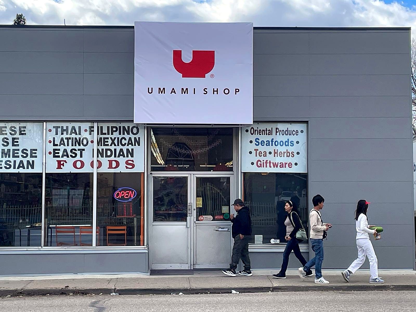 Umami Shop storefront with its new sign above the entrance and pedestrians on the sidewalk